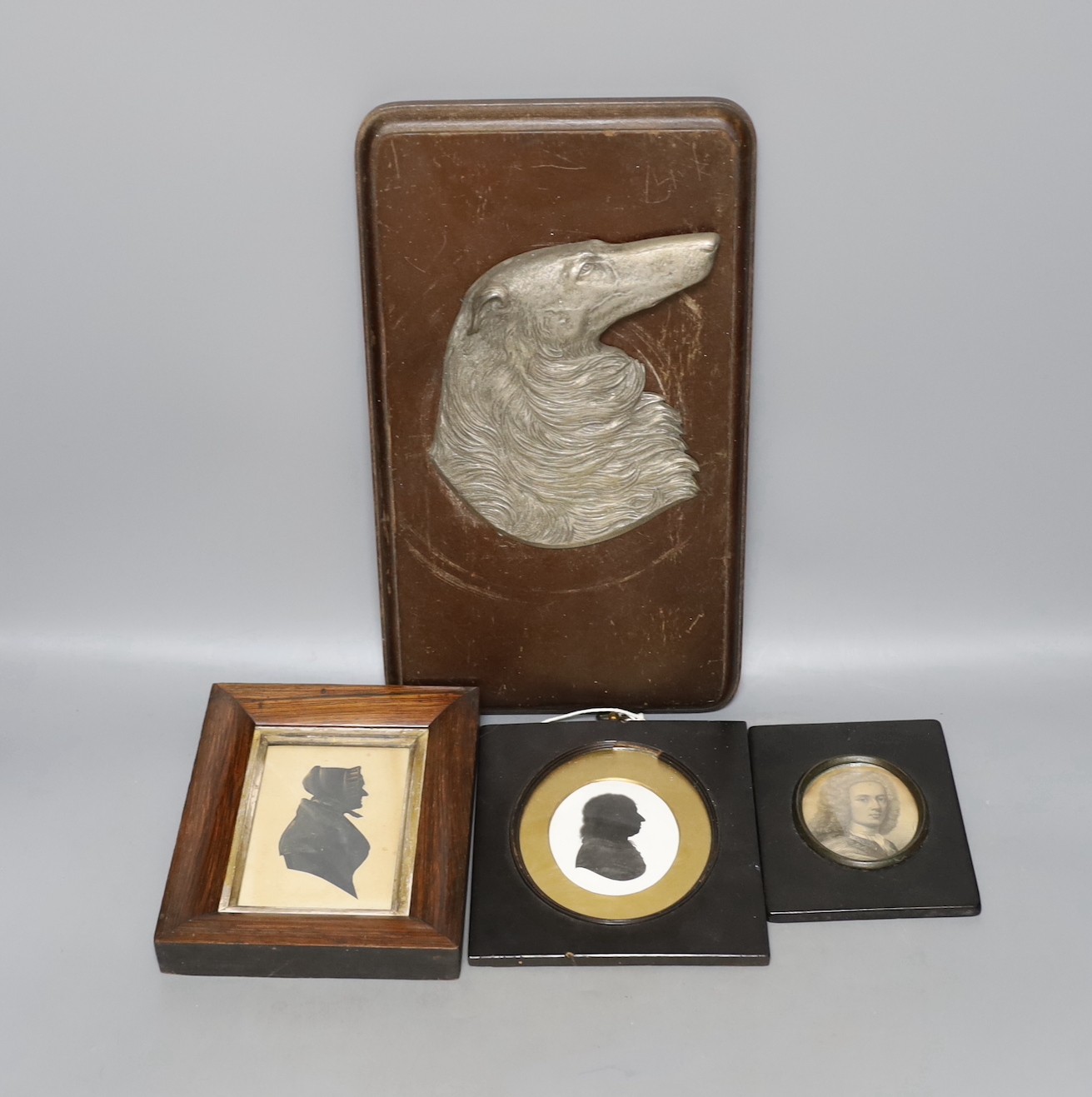 Two Victorian silhouette portraits, a printed monochrome bust, all framed together, with an early 20th century German relief of a borzoi, 33 x 19cm
